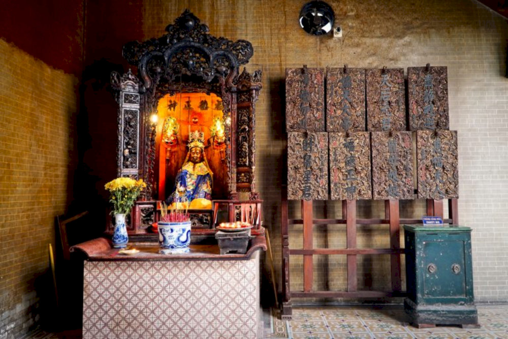 The side altars, adorned in red and gold, are where worshippers pray for prosperity and protection